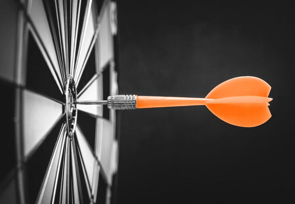 Dart hitting bullseye on dart board